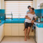 A joyful couple embracing in a bright kitchen, symbolizing love and happiness.